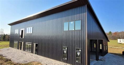 black metal barn house|black barndominium with wood accents.